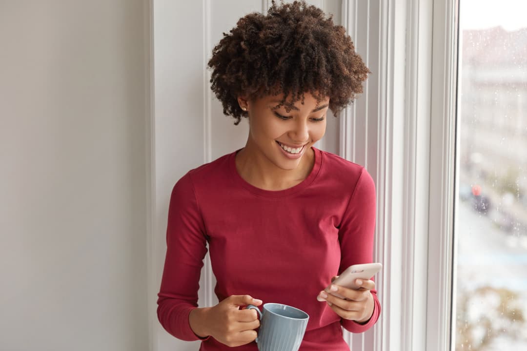 Woman with coffee checking her phone